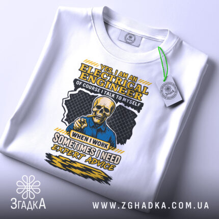 Футболка електрик інженер білого кольору, зображена зверху, на фоні світло-сірого кольору, принт з черепом у синій сорочці та текстом жовтого кольору, з етикеткою на рукаві.