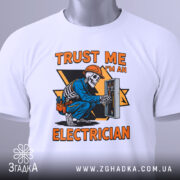 Футболка електрик білого кольору, зображена з верхнього ракурсу, на ній прикріплена етикетка, фон світло-сірий, принт з малюнком скелета-електрика в синій робочій формі, що працює з електричним щитом, текст на принті яскраво-оранжевий.