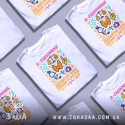 Футболка ендокринолог, біла, зображена на манекені, фон світло-сірий, принт кольоровий, містить текст "Я - ендокринолог. Збалансую ваші гормони та настрій" з малюнками хімічних формул та смайлів.