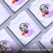 Футболка Girls Rule Art білого кольору, зображена з фронтального ракурсу на манекені, фон світло-сірий, принт з графічним зображенням статуї з навушниками та сонцезахисними окулярами, кольори принта: червоний, фіолетовий, жовтий, чорний.