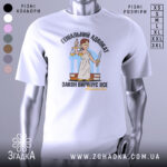 Футболка геніальний адвокат, біла, зображена на манекені з блискучого металу, фон світло-сірий, принт з адвокатом у білому одязі, що тримає ваги та меч, текст чорний і жовтий.