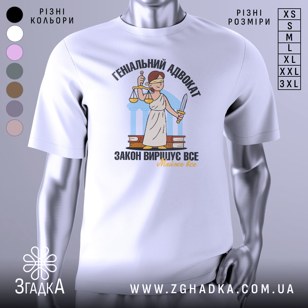 Футболка геніальний адвокат, біла, зображена на манекені з блискучого металу, фон світло-сірий, принт з адвокатом у білому одязі, що тримає ваги та меч, текст чорний і жовтий.