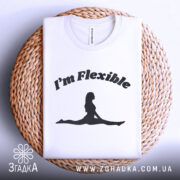 Футболка гнучка йога силует, біла, складена на плетеній кошику, фон світло-сірий, принт чорний з написом 'I'm Flexible' та силуетом жінки в позі розтяжки.