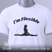 Футболка гнучка йога силует, біла, складена на столі, фон світло-сірий, принт чорний з написом 'I'm Flexible' та силуетом жінки в позі розтяжки, з етикеткою на зеленій стрічці.