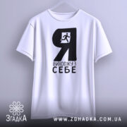 Футболка я виходжу з себе. Біла футболка з чорним принтом, зображення чоловіка, що біжить, розташоване зліва. Фон світло-сірий, футболка підвішена, видно з переднього ракурсу.