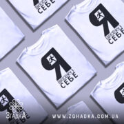 Футболка я виходжу з себе. Біла футболка з чорним принтом, зображення чоловіка, що біжить, розташоване зліва. Фон світло-сірий, футболка зображена з ракурсу спереду, на манекені.