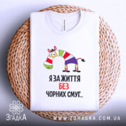 Футболка я за життя, білого кольору, складена на плетеній кошику, фон світло-сірий, принт з зеброю в смугастому одязі та написом "Я за життя без чорних смуг...".
