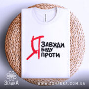 Футболка я завжди буду проти, білого кольору, зображена зверху на плетеній основі, фон світлий, принт чорного кольору з червоними акцентами, текст на футболці читається чітко.