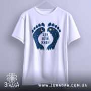 Футболка йди мрій живи, біла, зображена на вішалці, фон світло-сірий, принт у вигляді слідів з зірками та місяцем, напис чорного кольору.