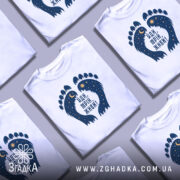 Футболка йди мрій живи, біла, зображена на манекені, фон світло-сірий, принт у вигляді слідів з зірками та місяцем, напис чорного кольору.