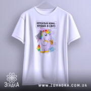 Футболка єдинорог нормальна жінка, біла, підвішена на вішалці, фон світло-сірий, принт з єдинорогом, який тримає ніж, текст зверху: 'Нормальна жінка – нудьга в сім'ї'.