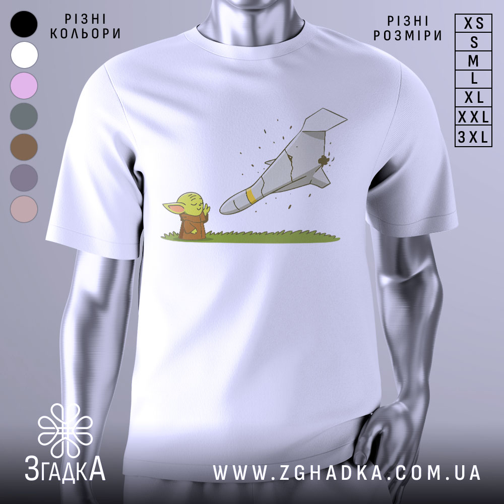 Futbolka Ioda Zupyniaie Shakhed Stylnyi Zhart 1 Футболка йода зупиняє шахед, біла футболка на манекені, зображення йоди, що дивиться на ракету, яка розбивається, фон світло-сірий, принт кольоровий, з зеленим йодою та сірим літаком.