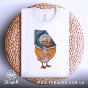 Футболка качур боєць білого кольору, складена на плетеній основі, фон світло-сірий, принт з качуром у капелюсі, що тримає гвинтівку, на жовтому колі.