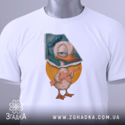 Футболка качур боєць білого кольору, складена на столі, фон світло-сірий, принт з качуром у капелюсі, що тримає гвинтівку, з етикеткою на рукаві.