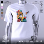 Футболка капібара білого кольору, зображена на манекені, з принтом капібари в кольоровій кепці та золотому ланцюгу, фон світло-сірий.