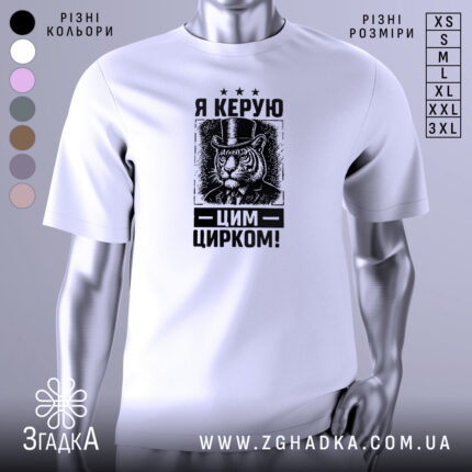 Футболка керую цим цирком, білого кольору, зображена на манекені з правого ракурсу, фон градієнтний сірий, принт з тигром у капелюсі та текстом "Я КЕРУЮ ЦИРКОМ!" у чорному кольорі.