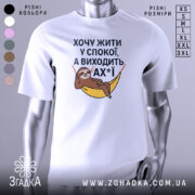 Футболка хочу жити спокійно, білого кольору, з фронтального ракурсу, на фоні світло-сірого градієнту, з принтом, що зображує лінивця, який лежить у гамаку, з текстом на українській мові.