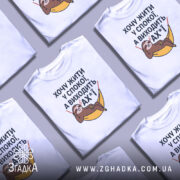 Футболка хочу жити спокійно, білого кольору, з фронтального ракурсу, на фоні світло-сірого градієнту, з принтом, що зображує лінивця, який лежить у гамаку, з текстом на українській мові.