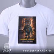 Футболка хороший хлопчик, біла, з верхнього ракурсу, на фоні світло-сірого градієнту, з принтом кота в джинсовій куртці, з етикеткою на зеленому шнурку.