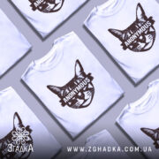 Футболка кіт анонімус білого кольору, зображена з правого ракурсу на манекені, фон світло-сірий, принт зображає кота з написом 'ANONYMOUS' у коричневому кольорі.