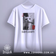 Футболка кіт сарказм, біла, підвішена на вішалці, фон світло-сірий, принт з чорним котом, який тримає сигару, з червоними смужками.