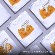 Футболка кіт це нормально. Біла футболка на манекені, з принтом оранжевого кота, що сидить на стільці серед вогню, з текстом 'Я в порядку'. Фон світло-сірий, деталі принта яскраві.