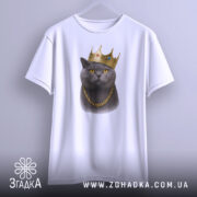 Футболка кіт у короні, біла, підвішена на вішалці, фон світло-сірий, принт зображає кота в золотій короні та ланцюгу, з чіткими деталями.