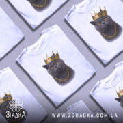 Футболка кіт у короні, біла, зображена з фронтального ракурсу на манекені, фон градієнтний сірий, принт зображає кота в золотій короні та ланцюгу.