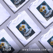 Футболка клоун жахів, біла, зображена на манекені, фон світло-сірий, принт з клоуном у соняшникових окулярах та чорними зубами.