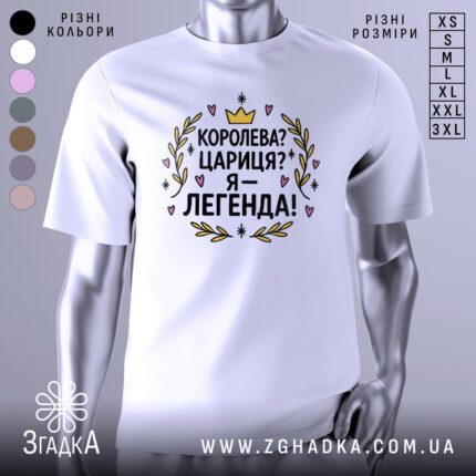 Футболка королева я легенда, біла, зображена з фронтального ракурсу, на нейтральному фоні, принт з текстом "Королева? Цариця? Я – легенда!" оформлений у кольорах жовтий, чорний, рожевий та зелений, оточений декоративними елементами.