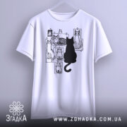 Футболка котячий світ, біла, підвішена на вішалці, фон світло-сірий, принт з чорними котами на фотографіях, один чорний кіт сидить спиною до глядача.