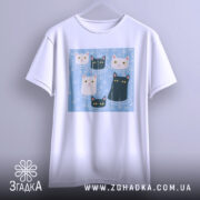 Футболка коти під дощем, біла, підвішена на вішалці, фон світло-сірий, принт з п'ятьма котами на блакитному фоні, добре видно деталі принта.