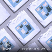 Футболка коти під дощем, біла, зображена на манекені, фон світло-сірий, принт з п'ятьма котами на блакитному фоні з краплинами дощу.