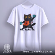 Футболка котик бариста, біла, підвішена на вішалці, фон світло-сірий, принт з котиком у фартуху, що тримає чашки з кавою, текст 'MR. BARISTA' під малюнком.