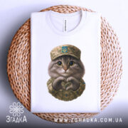 Футболка котик захисник, біла футболка на плетеній кошику, фон світло-сірий, принт з котиком у військовій формі, котик робить серце руками.