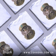 Футболка котик захисник, біла футболка на манекені, фон світло-сірий, принт з котиком у військовій формі з серцем на руках.