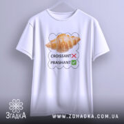 Футболка круасанний гумор Prashant, білого кольору, підвішена на вішалці, фон світло-сірий, принт з зображенням круасана та текстом 'CROISSANT' з червоним хрестиком і 'PRASHANT' з зеленим галочкою.