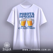 Футболка кум відпочиває, біла, підвішена на вішалці, фон світло-сірий, принт з двома пивними кухлями та написом 'РОБОТА ПОЧЕКАЄ' у синьому кольорі.