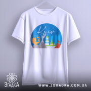 Футболка Київ міський стиль, біла, з фронтального ракурсу, підвішена на вішалці, фон світло-сірий, принт з зображенням архітектурних пам'яток Києва в кольорах блакитного, жовтого, зеленого та червоного.