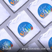 Футболка Київ міський стиль, біла, з фронтального ракурсу, на манекені, фон світло-сірий, принт з зображенням архітектурних пам'яток Києва в кольорах блакитного, жовтого, зеленого та червоного.