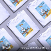 Футболка лелеки воєнного часу, біла, зображена на манекені, фон світло-сірий, принт з лелекою на електричному стовпі з жовтим фоном і блакитним небом.