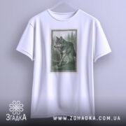 Футболка лісовий вовк, біла, підвішена на вішалці, фон світло-сірий, принт з лісовим вовком у зелених тонах, оформлений у рамку.