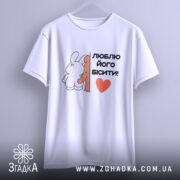 Футболка люблю його бісити, біла, підвішена на вішалці, фон світло-сірий, принт з двома персонажами, текст чорний з червоним сердечком.