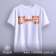 Футболка лисицьки білого кольору, підвішена на вішалці, фон світлий, принт з двома лисицями та написом 'ЛИСИЦЬКИ' оранжевого кольору.