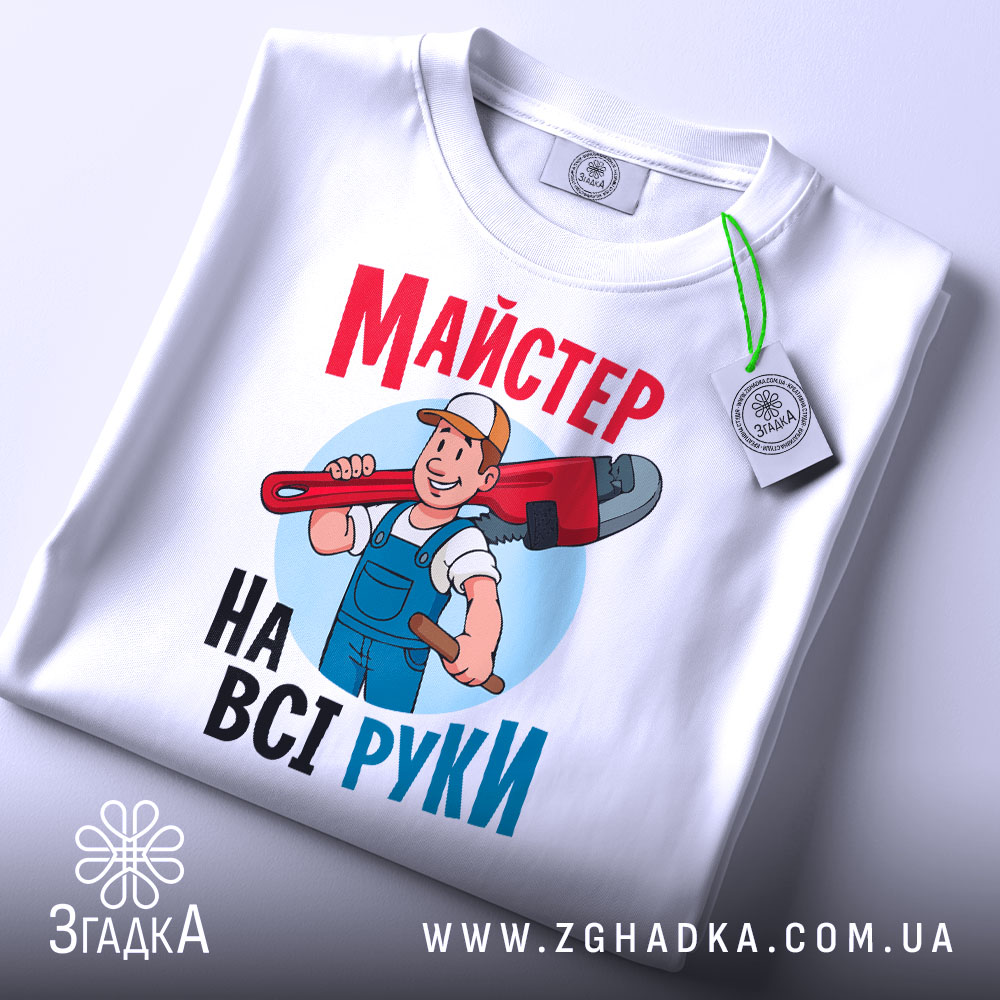Футболка майстер на всі руки, біла, зображена в складеному вигляді, фон світло-сірий, принт з майстром, який тримає червоний ключ, текст яскравий, червоний і блакитний, на футболці є етикетка з логотипом.