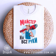 Футболка майстер на всі руки, біла, зображена в складеному вигляді на плетеній кошику, фон світло-сірий, принт з майстром, який тримає червоний ключ, текст яскравий, червоний і блакитний.