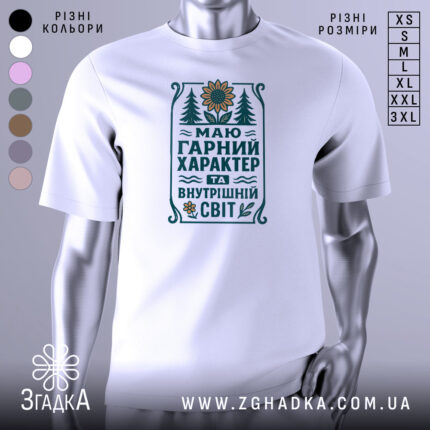 Футболка маю гарний характер. Біла футболка з коротким рукавом, зображена з правого ракурсу на манекені. На фоні світло-сірий градієнт. Принт містить текст та малюнки, включаючи соняшник і дерева, виконані в зелених і жовтих тонах.