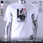 Футболка мавпа на велосипеді, біла, зображена на манекені, фон нейтральний, принт зображає мавпу на велосипеді з написом 'LIFE'.