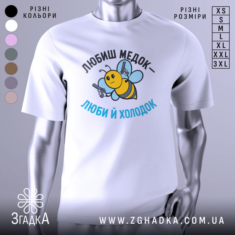 Футболка медок холодок, біла, зображена на манекені, фон світло-сірий, принт з бджолою, яка тримає пістолети, текст чорного та блакитного кольору.