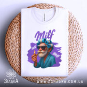 Футболка milf білого кольору, складена на плетеній кошику, з принтом старшого чоловіка в окулярах та з бігуді, який тримає сигарету, фон світло-сірий, принт яскравий з фіолетовими елементами.